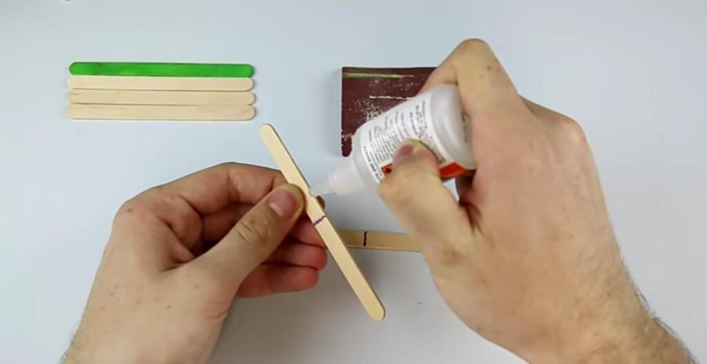 Applying Glue on an Ice Cream Stick with Glue Gun