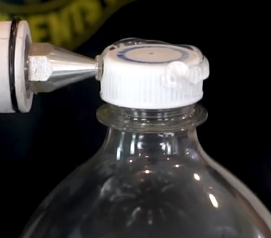 Applying Hot Glue to Plastic Bottle Cap