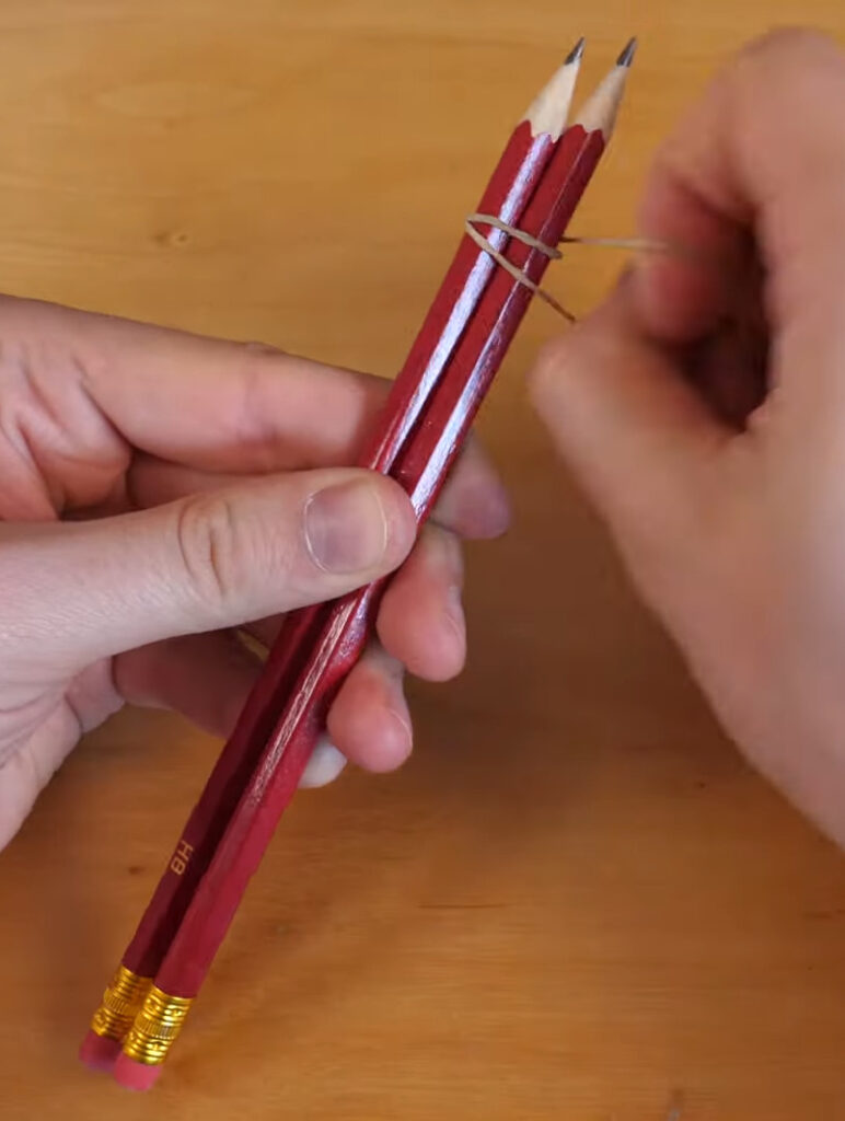 Two Pencils Joined with Small Rubber Bands